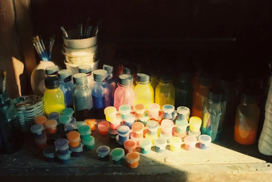 Botol bekas yang dipotong dan dihias menjadi tempat alat tulis, dengan cat akrilik warna-warni